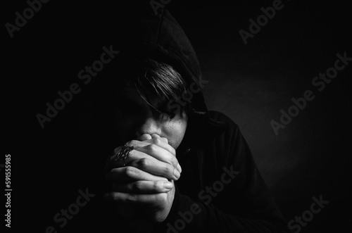 Young man praying in studio photo