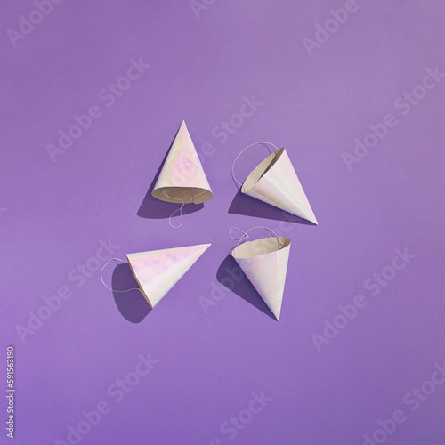 Free Download Four paper birthday party hats on purple background. Minimal concept. - GFXLoad