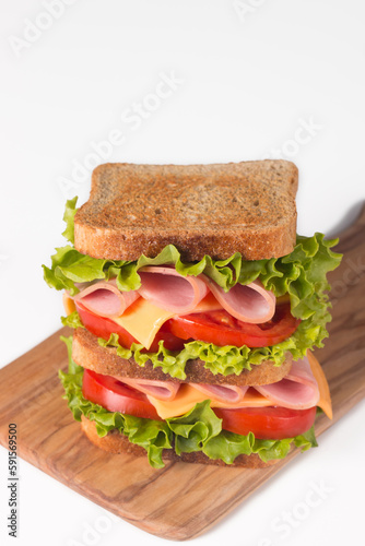 Club sandwich with ham, cheese, tomato and lettuce. 