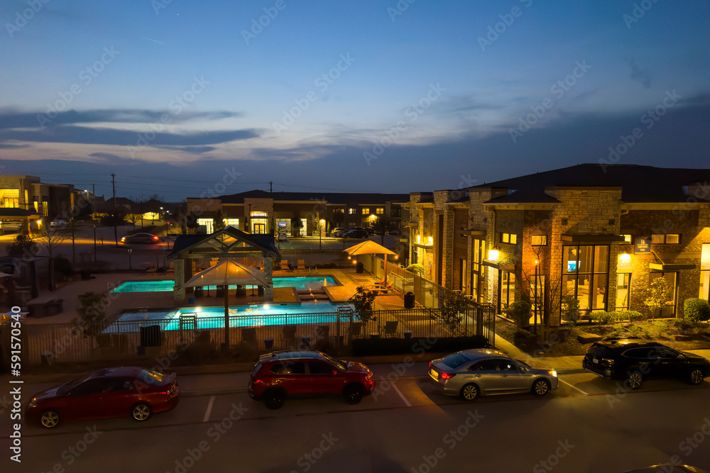 Outdoor urban view of modern real estate homes with parking gs, swimming pool in evening, luxury residential.