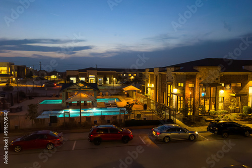 Outdoor urban view of modern real estate homes with parking gs, swimming pool in evening, luxury residential. © khosrork