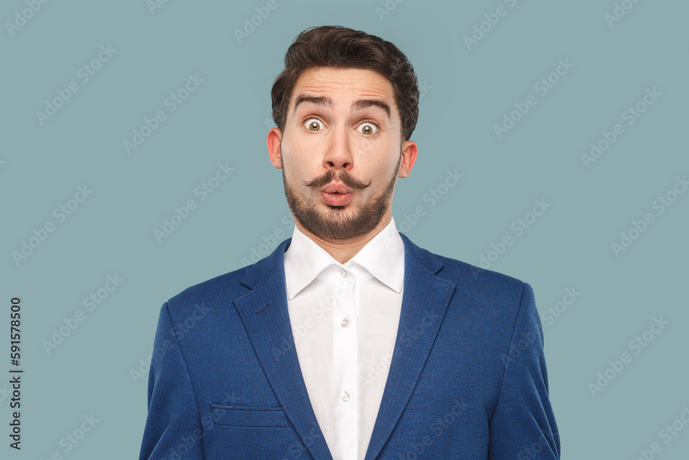 Wow. Portrait of shocked surprised man with mustache standing looking at camera with big eyes, sees something amazed, wearing official style suit. Indoor studio shot isolated on light blue background. Wow. Portrait of shocked surprised man with mustache standing looking at camera with big eyes, sees something amazed, wearing official style suit. Indoor studio shot isolated on light blue background.