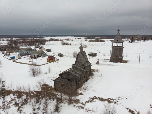 Village on the edge of a cliff. Church and bell tower on the banks of the Northern Dvina. Russia, Arkhangelsk region, Chukhcherma village