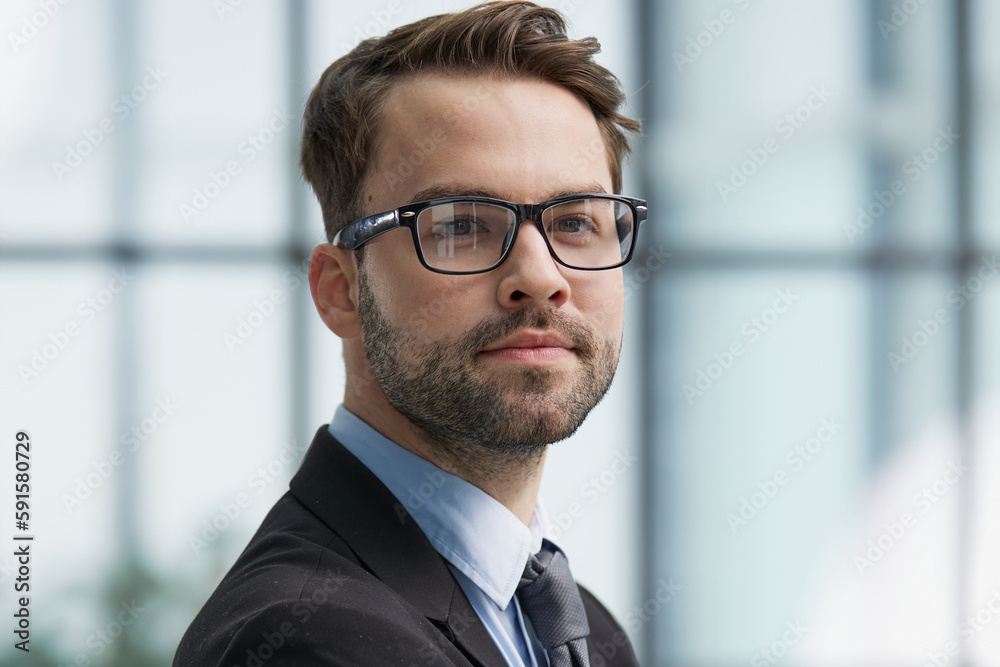 Portrait man wearing spectacles and looking at camera indoor.