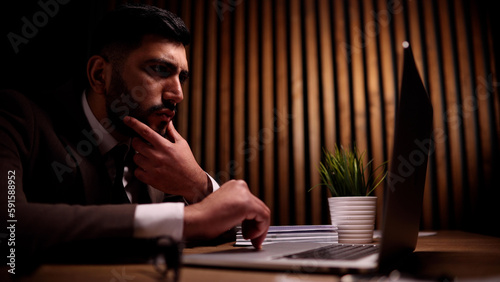 Obraz na plátně Business male is sitting in front of a laptop