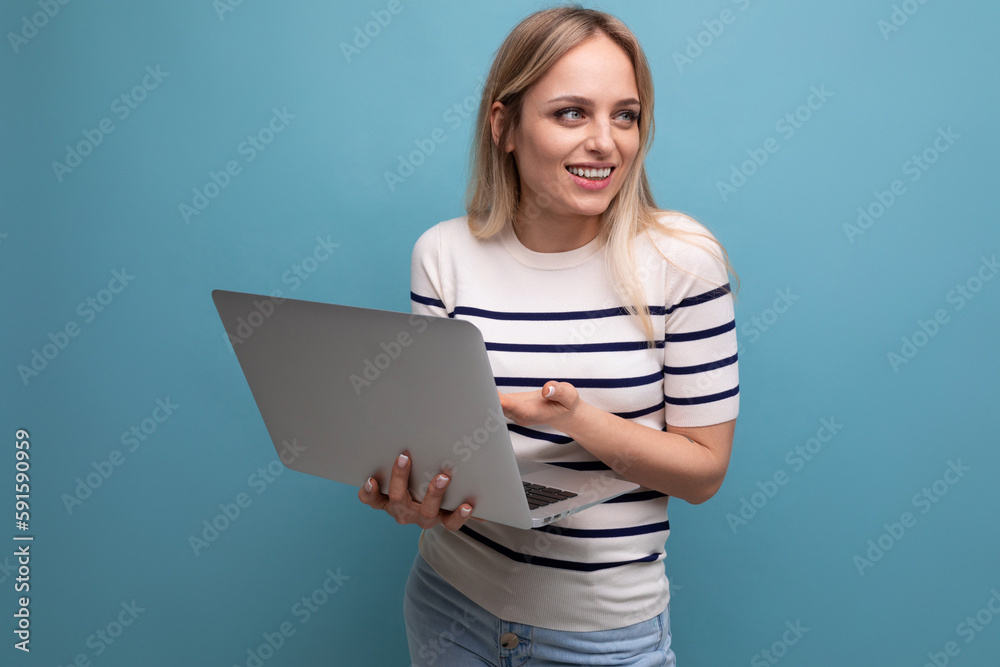 smiling confident young business woman with a laptop in her hands on a blue isolated background with copy space smiling confident young business woman with a laptop in her hands on a blue isolated background with copy space