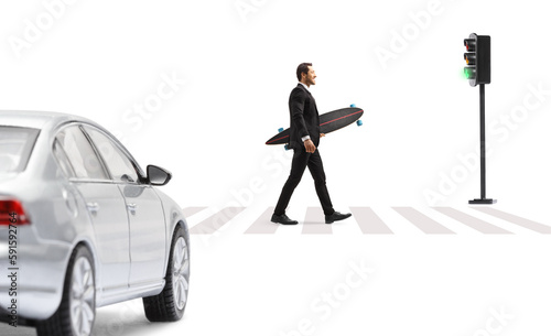 Full length profile shot of a businessman in a suit crossing a street and holding a longboard