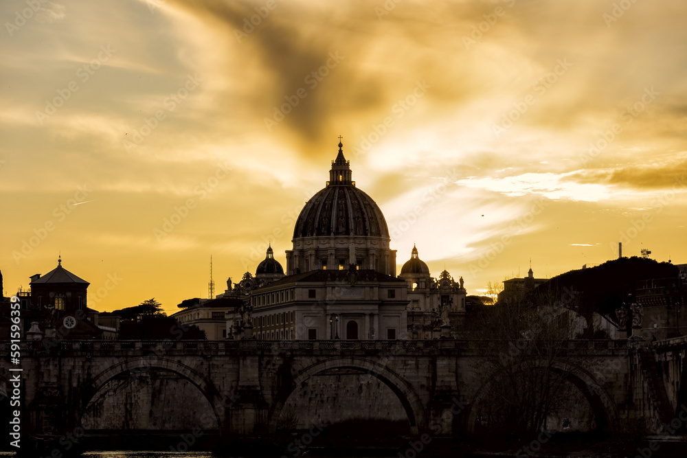 Romantic sunset view of Rome with the silhouette of the Vatican in front of a sunset of yellow and orange clouds. conceptual photo