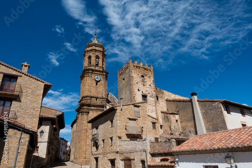 Iglesia de la Purificación - Iglesuela del Cid - Torre campanario sobre cielo azul con nubes photo