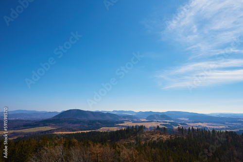 Beautiful mountains covered with evergreen forest on sunny day. Natural landscape with mountain ranges and valleys © Lazy_Bear
