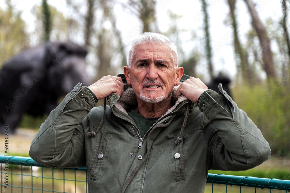 portrait of expressive middle aged man posing in front of mammoth models in a public park