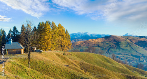 Misty early daybreak in autumn  mountain and wooden chapel on mountain top (Jasynja Village, Carpathian ). photo