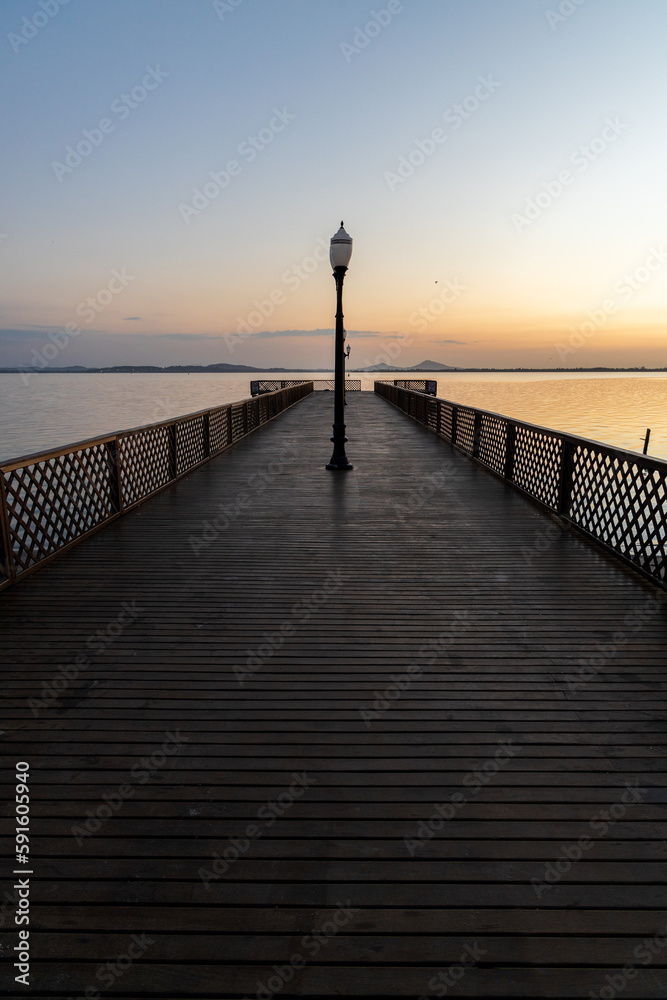 wooden pier over lagoon during sunrise wooden pier over lagoon during sunrise