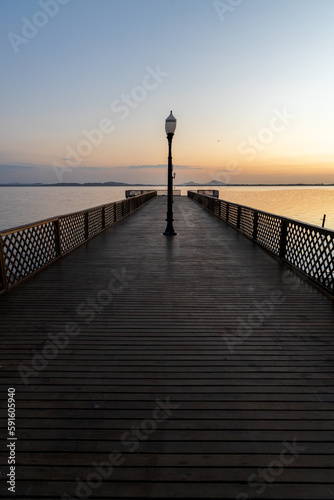 wooden pier over lagoon during sunrise