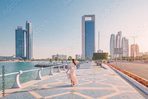 Obraz na płótnie Strolling along the Abu Dhabi Corniche, a scenic waterfront promenade with stunning views of the Arabian Gulf and the city's iconic skyscrapers, is a must-do for any visitor to the UAE's capital. w salonie