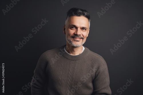 Handsome middle-aged man in a sweater on a dark background