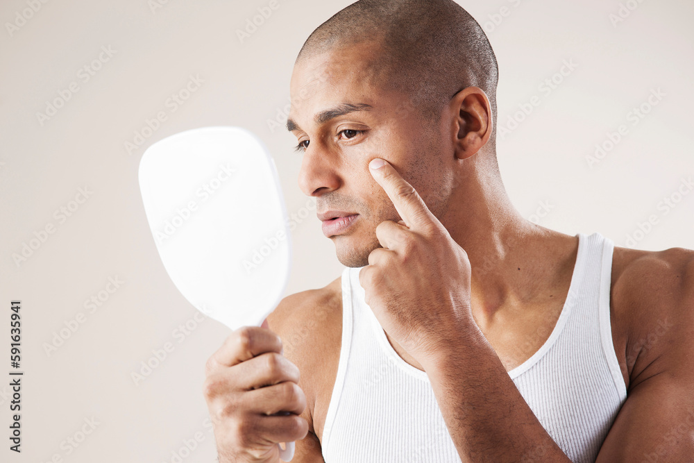 Man Looking at his Face in a Mirror in Studio with White Background