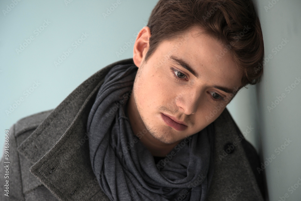 Head and Shoulder Portrait of Young Man wearing Grey Scarf and Jacket, Absorbed in Thought, Studio Shot on Grey Background Head and Shoulder Portrait of Young Man wearing Grey Scarf and Jacket, Absorbed in Thought, Studio Shot on Grey Background