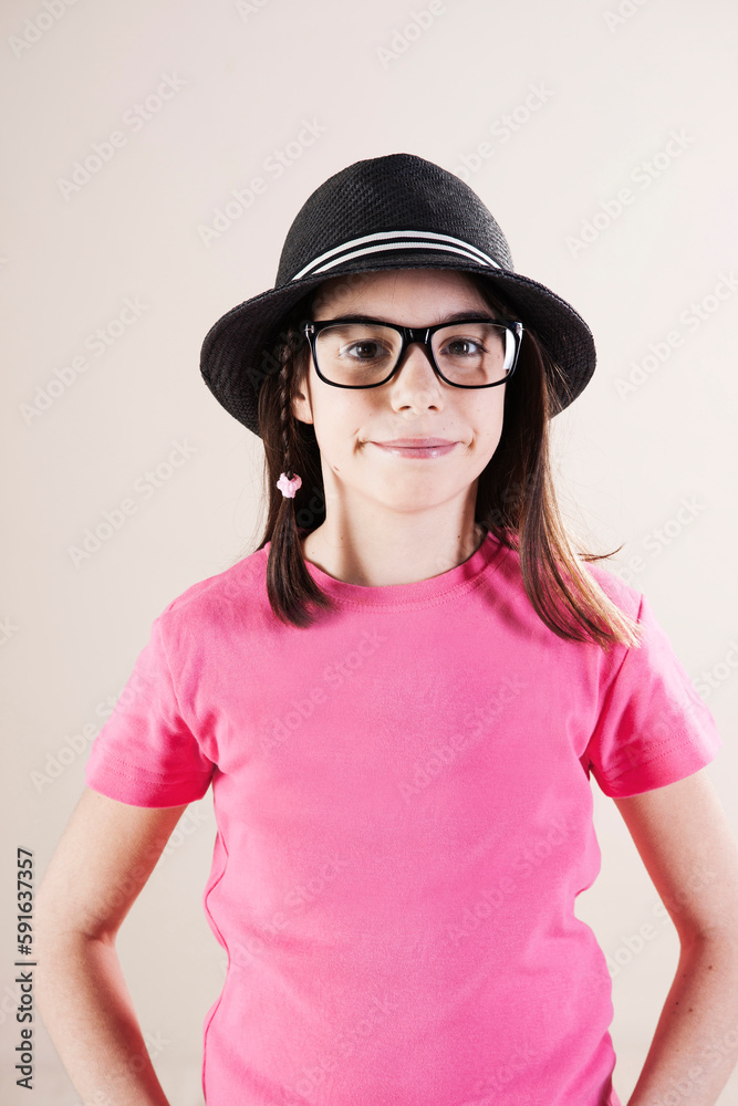 Portrait of Girl wearing Fedora and Horn-Rimmed Eyeglasses, Looking at Camera, Studio Shot Portrait of Girl wearing Fedora and Horn-Rimmed Eyeglasses, Looking at Camera, Studio Shot