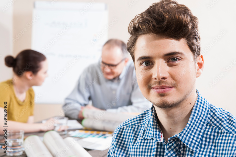 Portrait of Young Businessman with Colleagues Meeting in the Background Portrait of Young Businessman with Colleagues Meeting in the Background