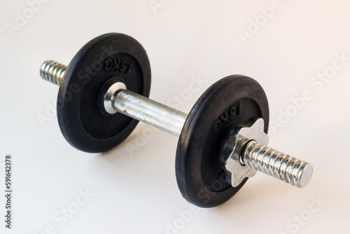 A total of three kilograms of metal dumbbells, on a white surface.1,5 kg is written on the disc