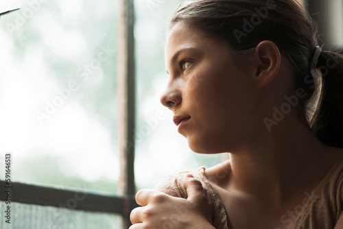 Girl looking out of window, Germany