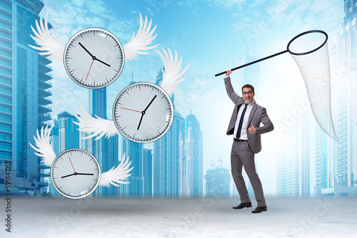 Deadline concept with businessman catching clocks photo