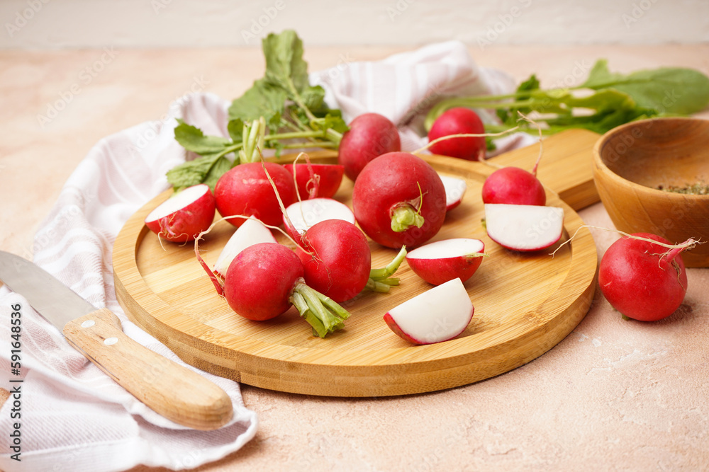 Fresh red radish on cutting board on beige background. Fresh red radish on cutting board on beige background.