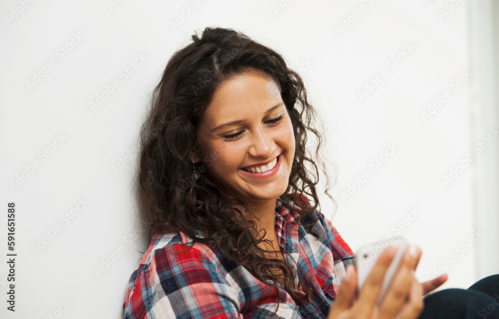 Close-up portrait of teenage girl looking at cell phone and smiling, Germany Close-up portrait of teenage girl looking at cell phone and smiling, Germany