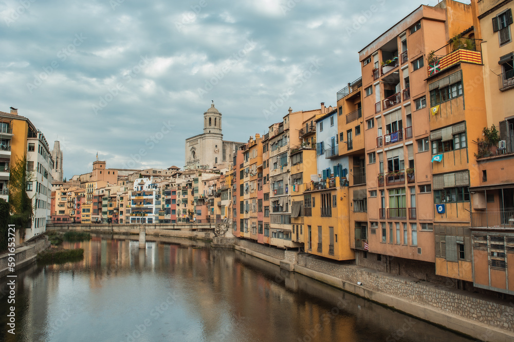 Riu Onyar through Girona city. Iconic river in Catalonia passing by the old town houses. Catedral de Girona.