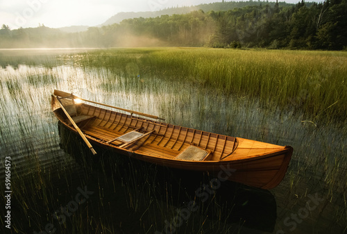 Adirondack guide canoe floats on Connery Pond at sunrise in Adirondack Park; New York, United States of America