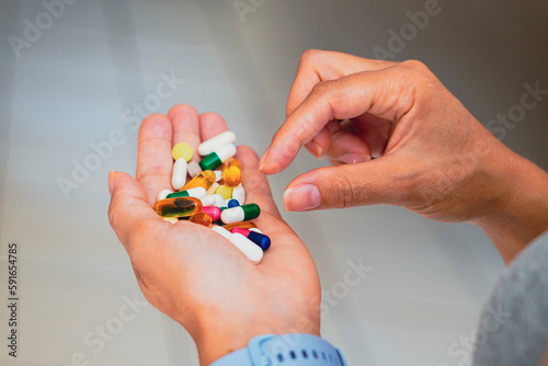 A person holds several medicine pills in his hand