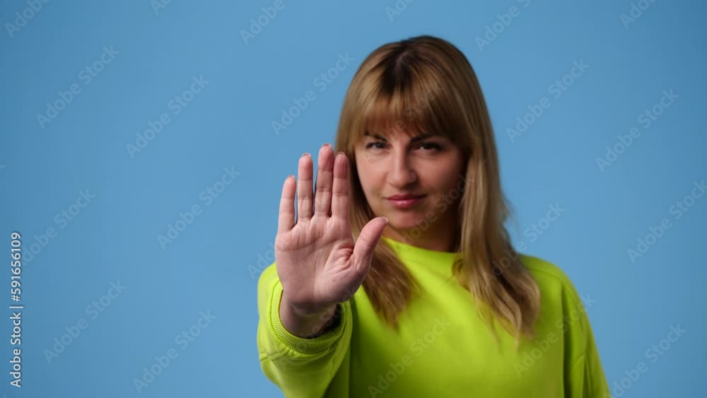 4k video of one girl showing stop sign over blue background. 4k video of one girl showing stop sign over blue background.