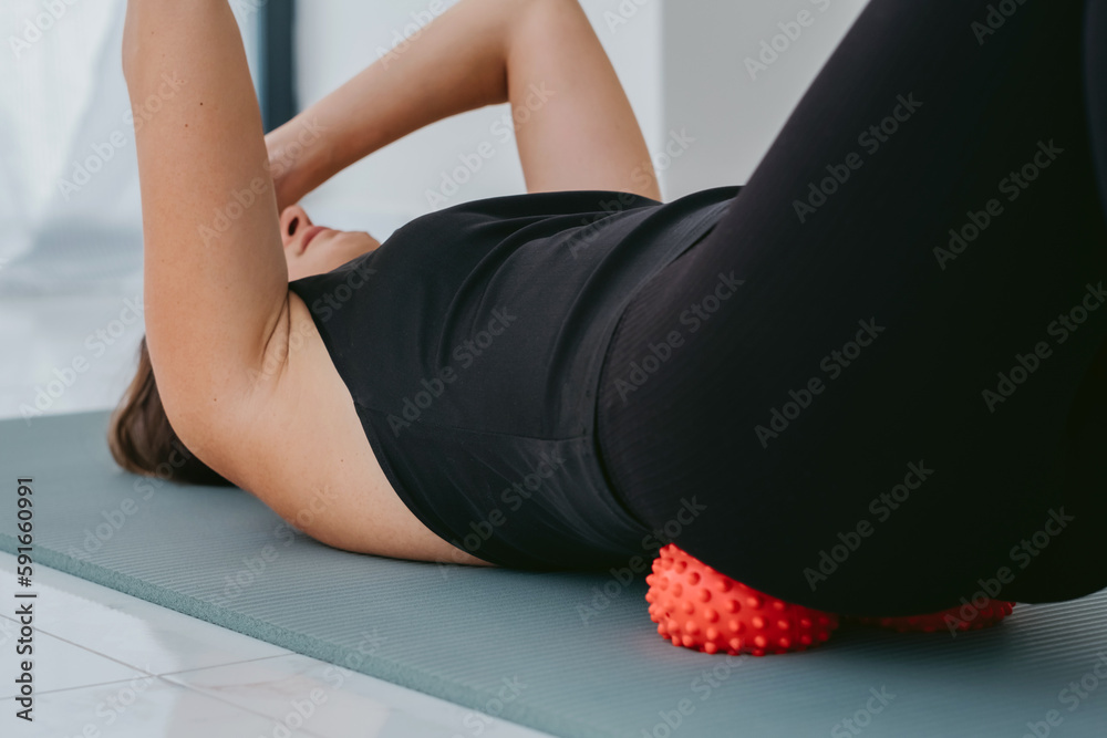Woman lying on small balls to eliminate back pain, massage stiff