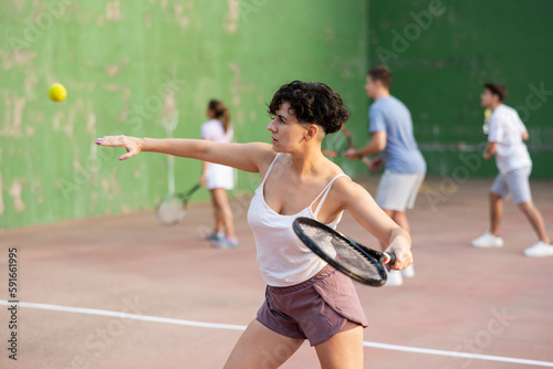 Expressive resolved fit girl playing frontenis ball friendly match on outdoors court © JackF