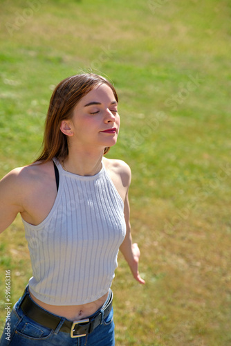 Obraz na plátně young girl standing with her arms outstretched behind her breathing deeply with