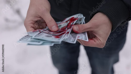Illegal earnings, Criminal wealth, Counting cash. Hands of a man are reckoning up dollars smeared with blood. photo