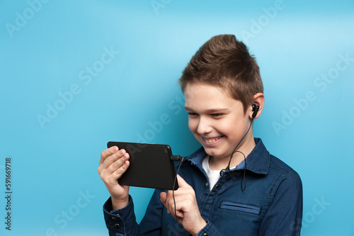 Caucasian boy browses the Internet with a tablet