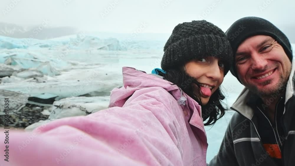 Funny travelous couple taking self portrait photograph on Iceland having fun on travel by Jokulsarlon glacial lagoon / glacier lake. Tourists enjoying beautiful Icelandic nature landscape Vatnajokull. Funny travelous couple taking self portrait photograph on Iceland having fun on travel by Jokulsarlon glacial lagoon / glacier lake. Tourists enjoying beautiful Icelandic nature landscape Vatnajokull.