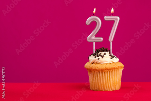 Candle number 27 - Cake birthday in rhodamine red background