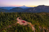 Drone shot of a pickup truck in front of volcanic mountain. Mount Rainier in the background. A perfect spot for camping off the grid. Copy space