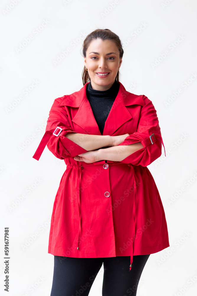 Confident woman in red with expressive gaze, arms crossed Confident woman in red with expressive gaze, arms crossed