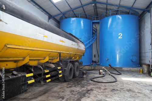 road tankers and storage tanks.  Process of loading vegetable oil from vertical tank containers to road tank trucks in a biodiesel storage warehouse