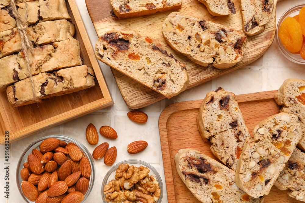 Wooden boards with tasty biscotti cookies and nuts on table, closeup