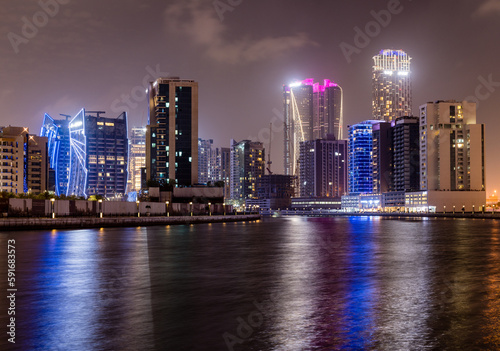 Night view of skyline of apartments buildings alongside canal in Business Bay