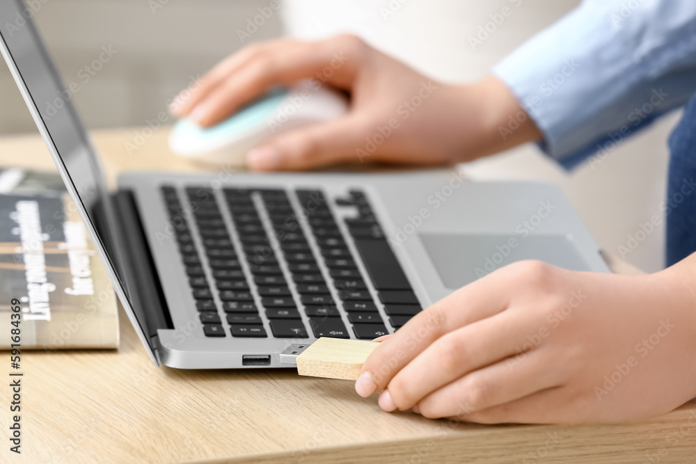 Woman with USB flash drive and laptop at wooden table, closeup Woman with USB flash drive and laptop at wooden table, closeup