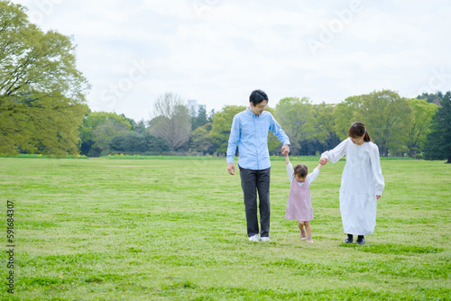 公園で手を繋ぐ家族 © taka