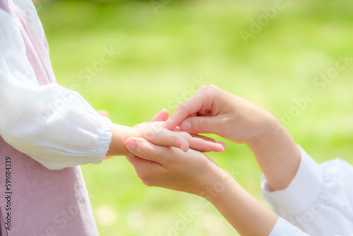 女の子の手を握るお母さん
