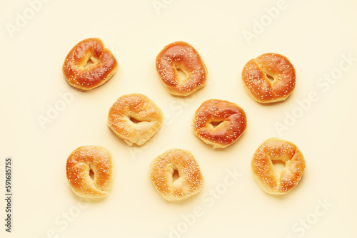Tasty bagels with sesame seeds on beige background