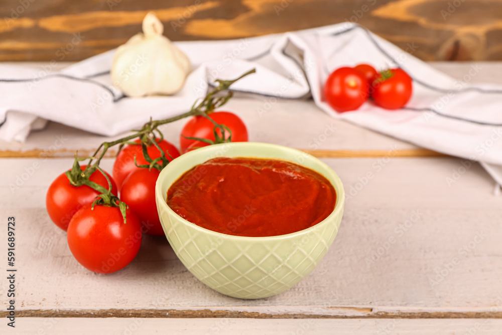 Bowl with tasty tomato paste and fresh vegetables on table Bowl with tasty tomato paste and fresh vegetables on table